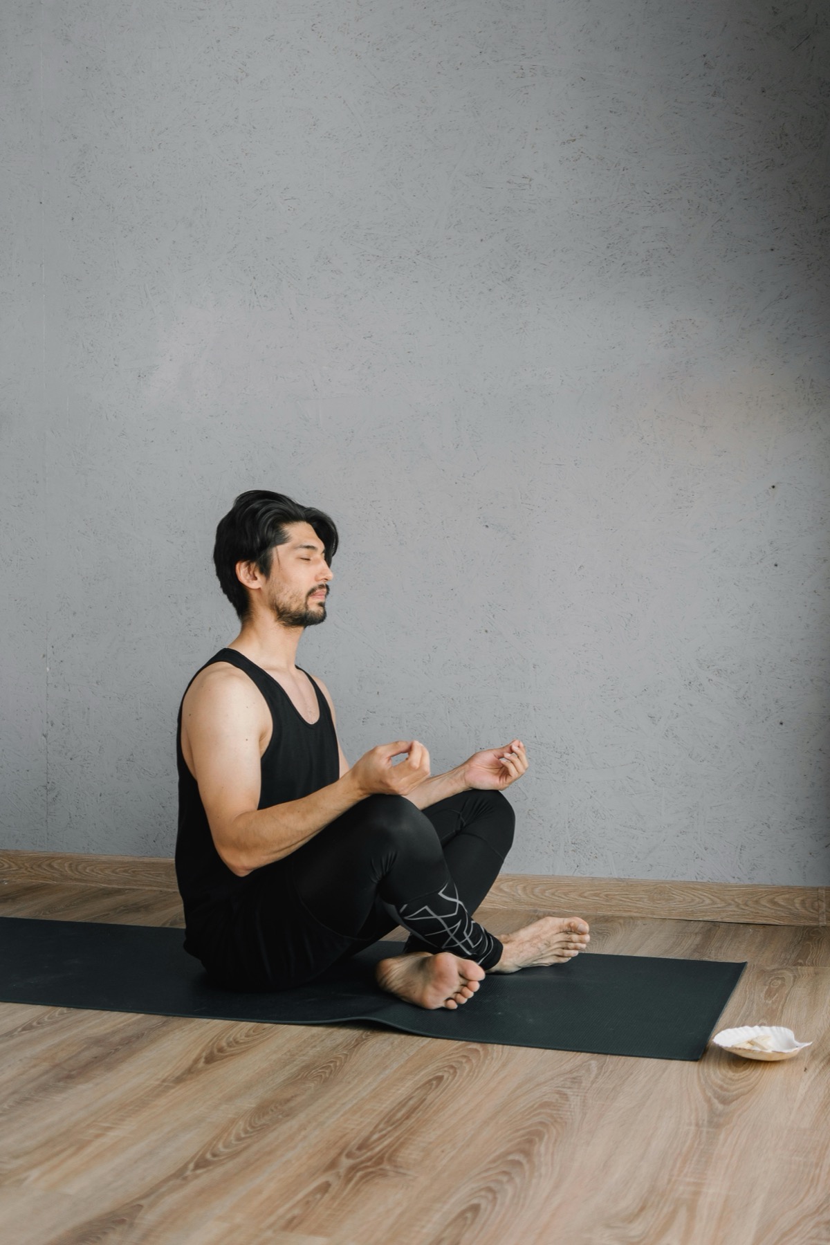 Mann som mediterer på yogamatte