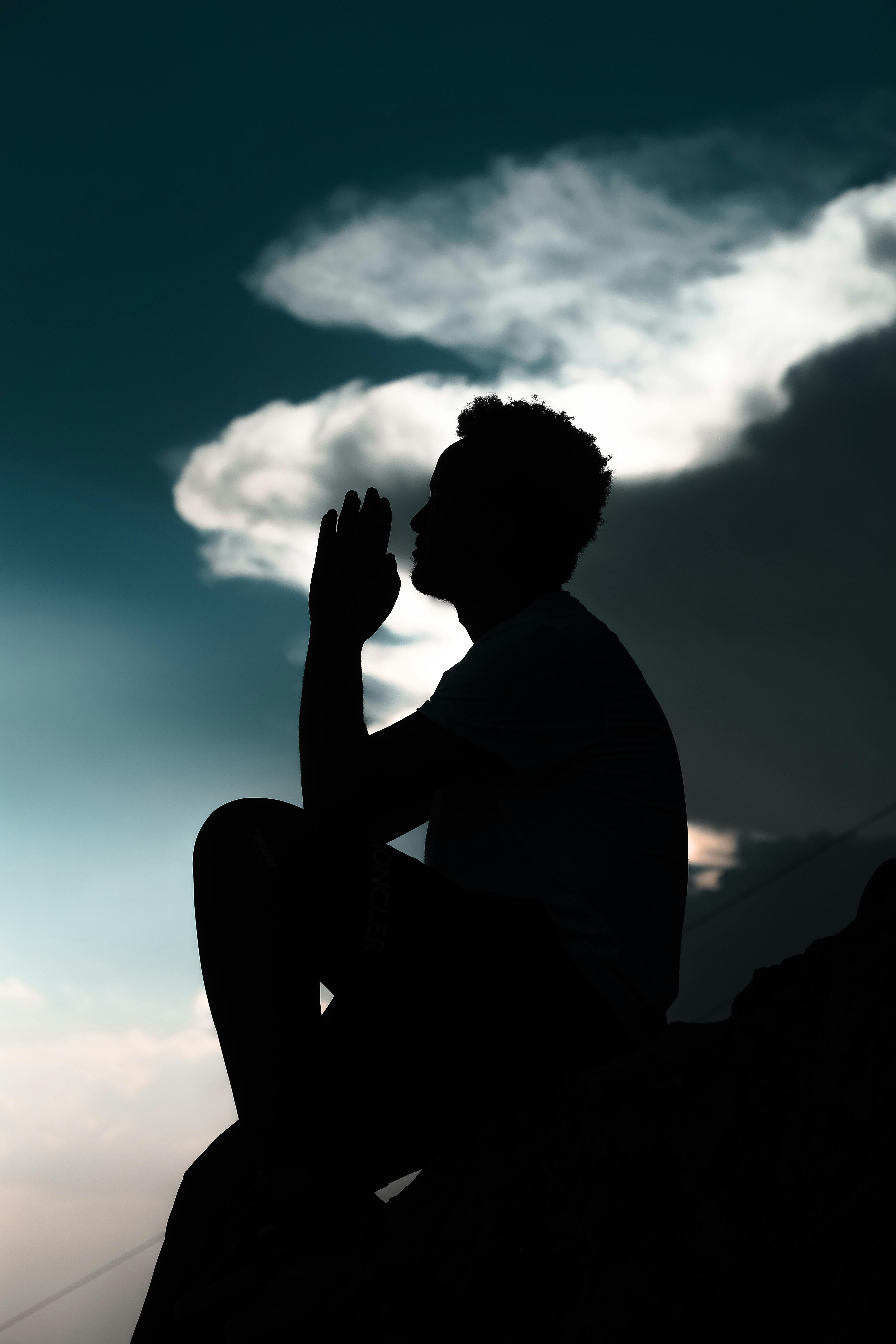 Mann i stille meditasjon mot himmelen